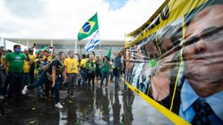 أنصار الرئيس البرازيلي يير بولسونارو يرمون بالونات المياه خلال احتجاج ضد إجراءات الإغلاق