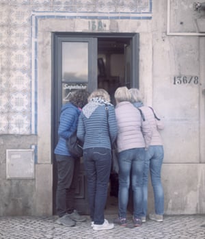 السياح ينظرون إلى متجر في حي Graça في لشبونة.
