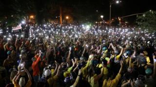 كجزء من مظاهرة سلمية في المدينة مساء الاثنين ، سار آلاف المتظاهرين في الشوارع وهم يحملون هواتف محمولة مضاءة عالياً