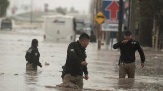 رجال الشرطة يخوضون فيضانات شديدة بسبب الأمطار الغزيرة التي تؤثر على مدينة سالتيلو في ولاية كواويلا الشمالية ، المكسيك 26 يوليو 2020