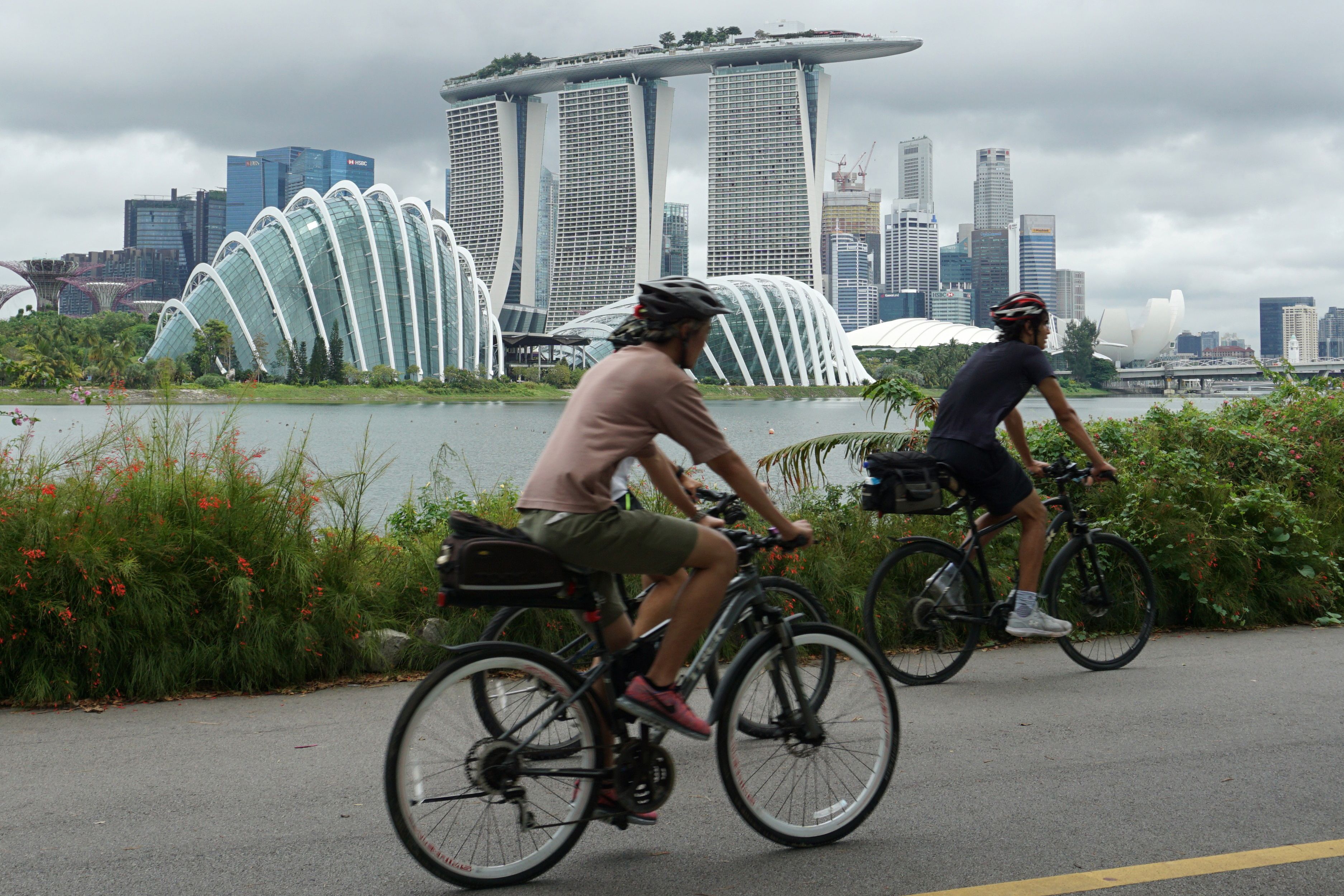 يركب راكبو الدراجات على طول خليج مارينا المطل على منطقة الأعمال المالية في سنغافورة في 14 يوليو.