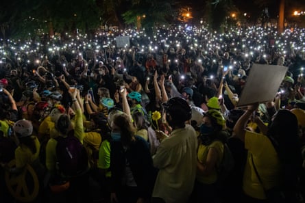 يمسك المتظاهرون بأضواء الهواتف المحمولة أثناء تجمعهم في مركز العدالة والمحكمة بينما يحاول الفيدراليون التدخل بعد أسابيع من الاحتجاجات في بورتلاند.