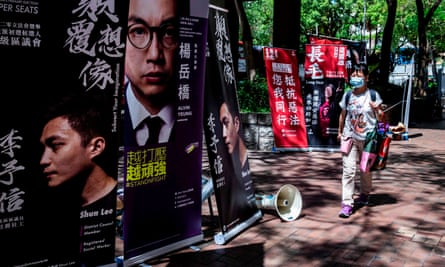 امرأة تسير على علامات الحملة السابقة خلال الانتخابات الأولية في هونغ كونغ. وصوت ما يصل إلى 600 ألف شخص فيما اعتبر رفضًا لقوانين الأمن الجديدة.