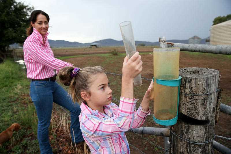 فيليسيتي مومن ، 7 سنوات ، تتحقق من مقياس المطر مع والدتها جانيس مومن في مزرعة العائلة في شمال غرب نيو ساوث ويلز في فبراير. 