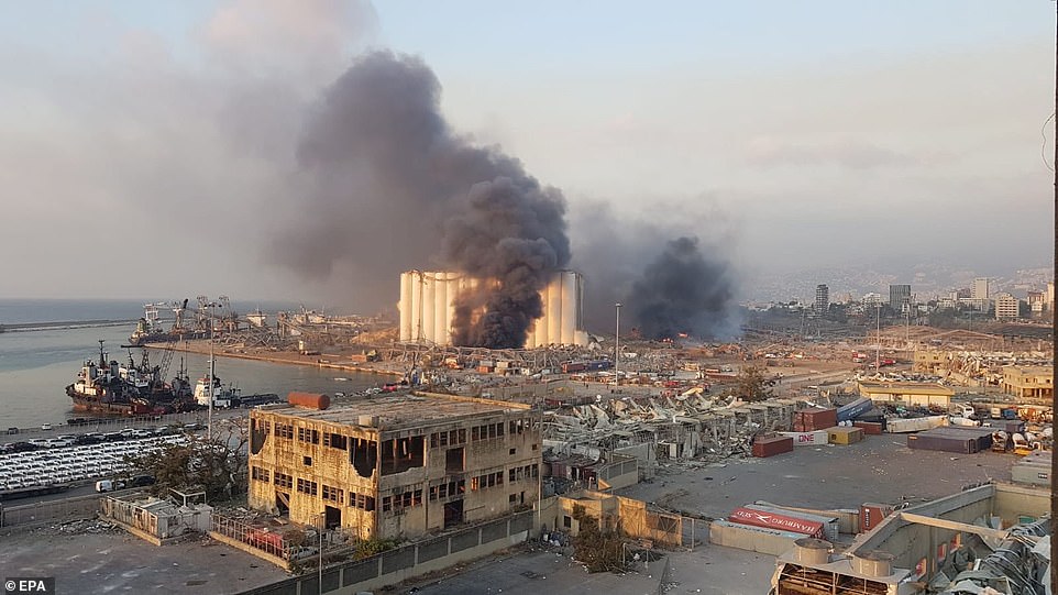 صورة هاتف محمول تُظهر منظرًا عامًا لمنطقة الميناء مع دخان يتصاعد من منطقة انفجار كبير ، مع أضرار وحطام بعد أن هز انفجار كبير منطقة المرفأ في بيروت
