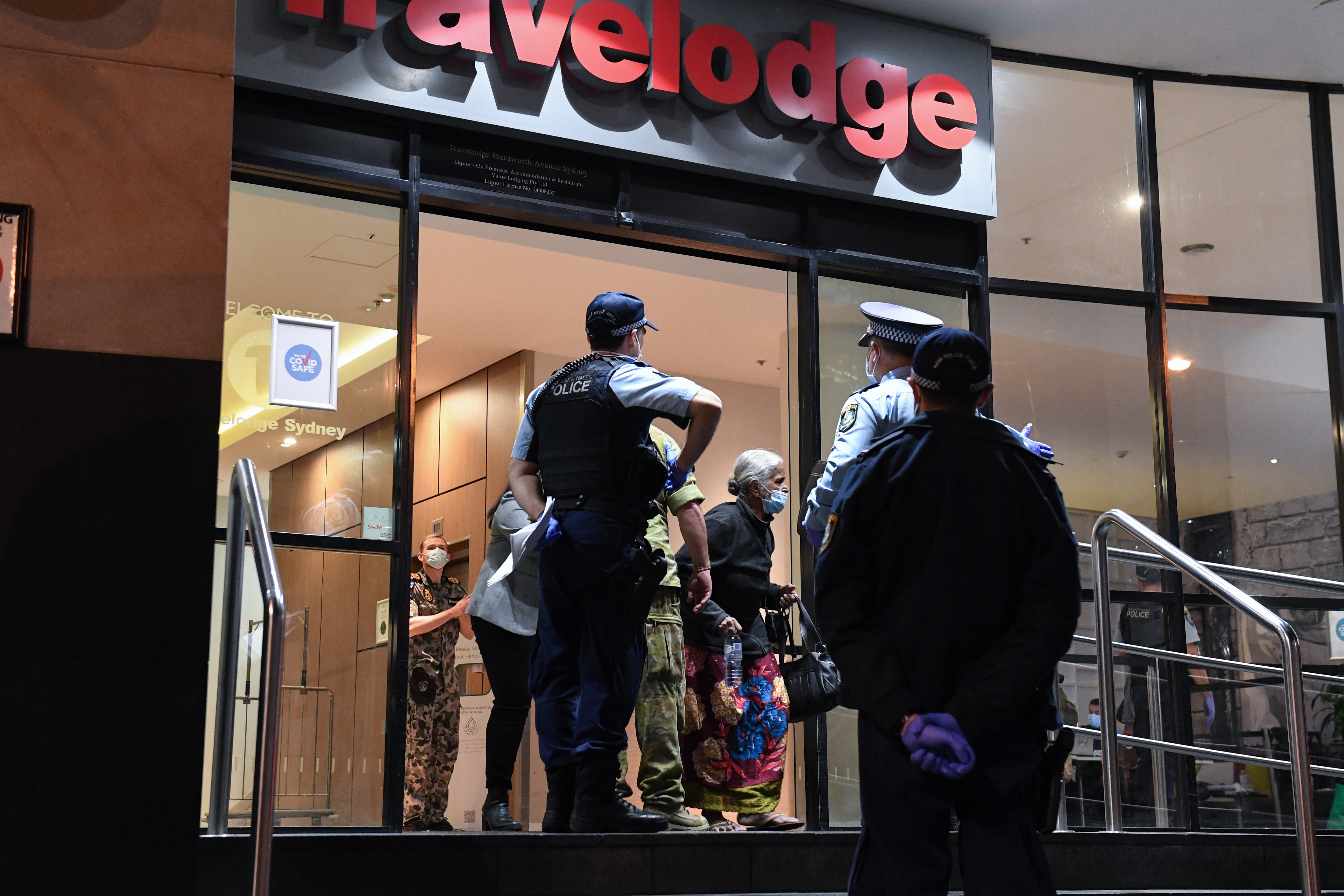 الضيوف المغادرون Travelodge في سيدني تحت حراسة الشرطة في 25 أغسطس 2020.