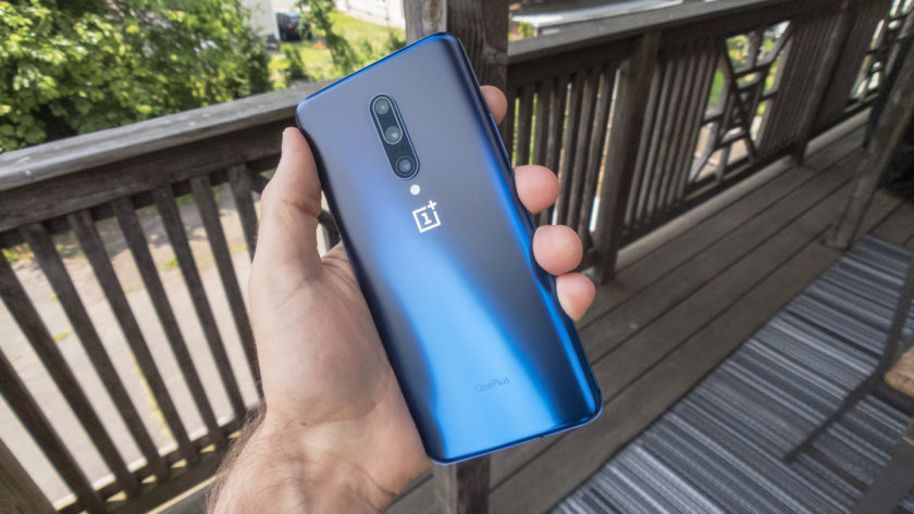 يد تمسك OnePlus 7 Pro بحيث يمكنك رؤية الجزء الخلفي وهو لون Nebula Blue.