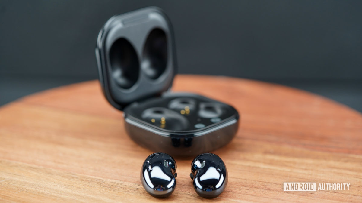 صورة لـ Samsung Galaxy Buds Live خارج العلبة على سطح خشبي.