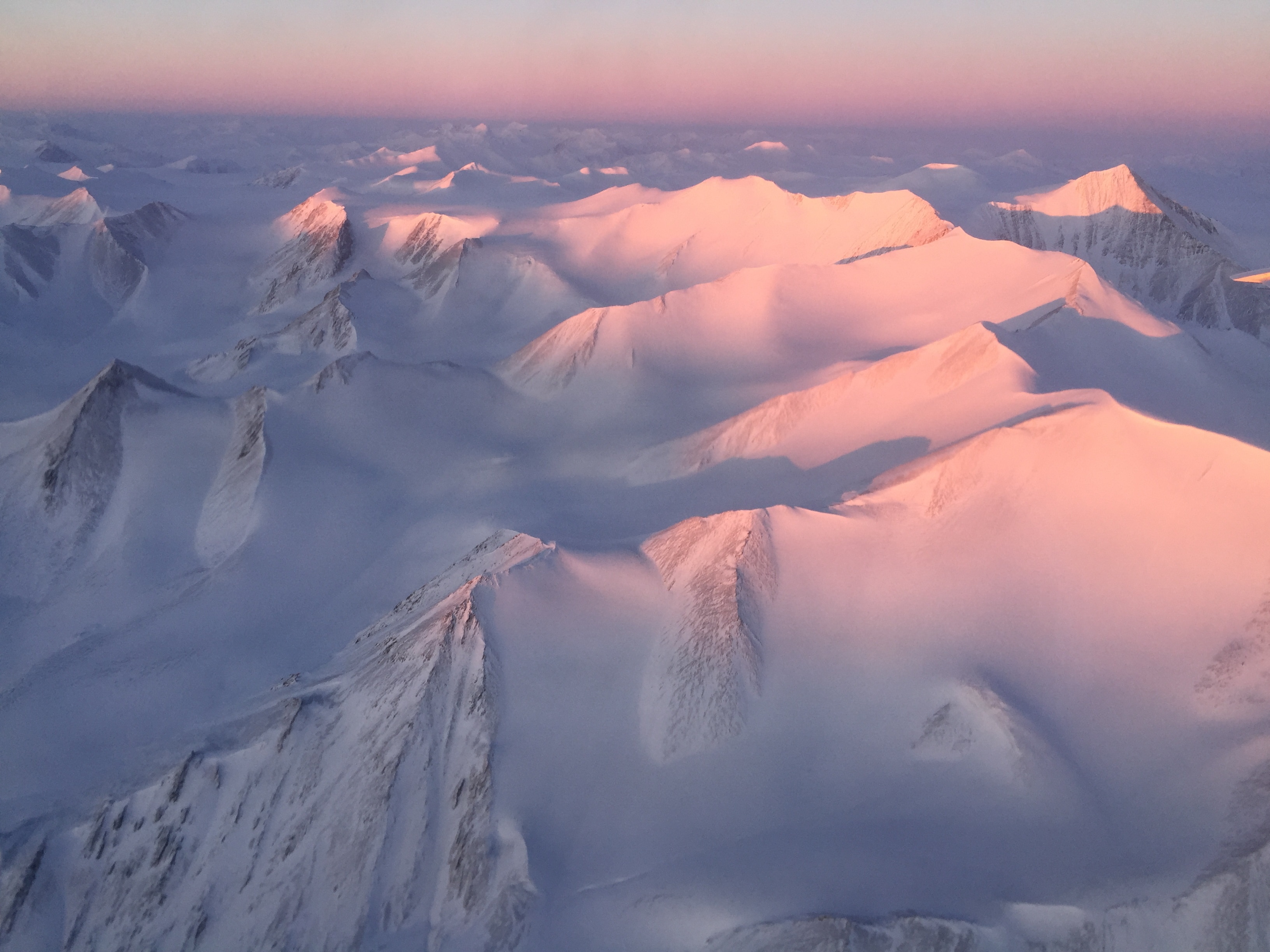 استحمت قمم جبال Ellesmere Island بالضوء عندما بدأت الشمس في الذروة فوق الأفق خلال الرحلة الأولى لعملية IceBridge في حملتها في القطب الشمالي لعام 2017. 