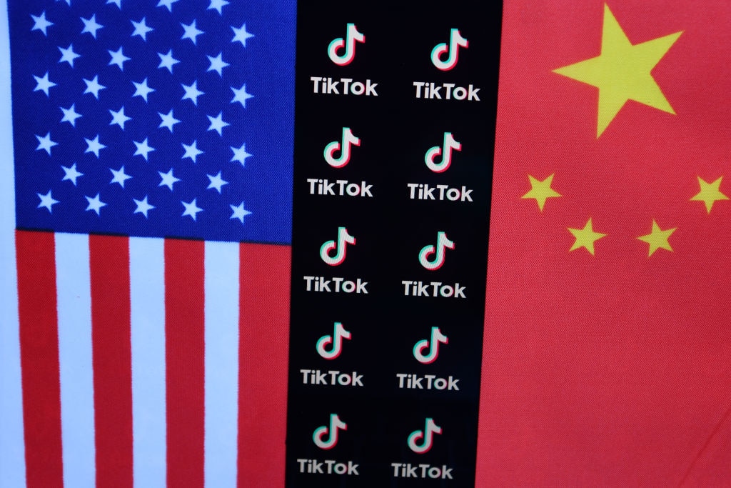 يظهر شعار TikTok بين أعلام الولايات المتحدة والصين
