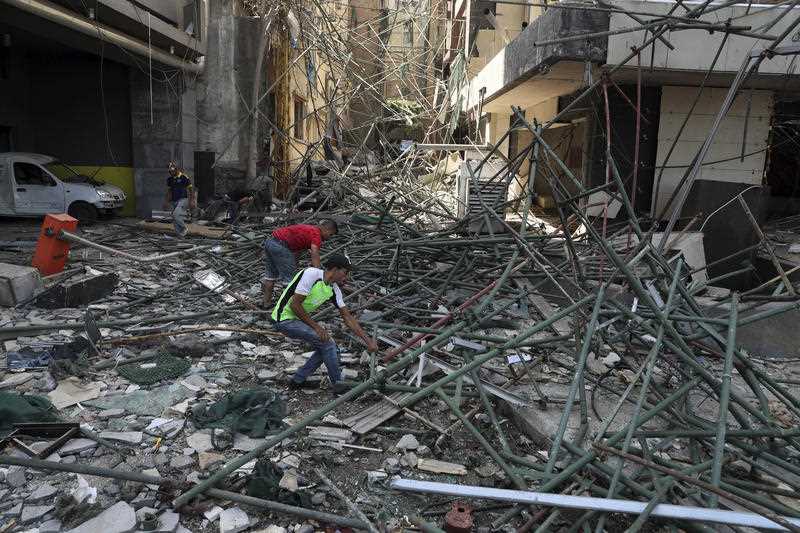 عمال يزيلون الركام من المباني المتضررة بالقرب من موقع انفجار يوم الثلاثاء ضرب ميناء بيروت ، لبنان ، الخميس 6 أغسطس ، 2020.