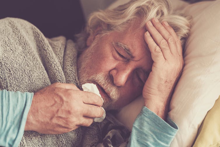 رجل مسن في الفراش مع حمى.