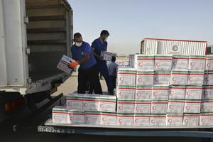 عمال في إيران يفرغون صناديق إمدادات المساعدات من شاحنة لتحميلها على متن طائرة متجهة إلى بيروت ، لبنان (Vahid Salemi / AP)