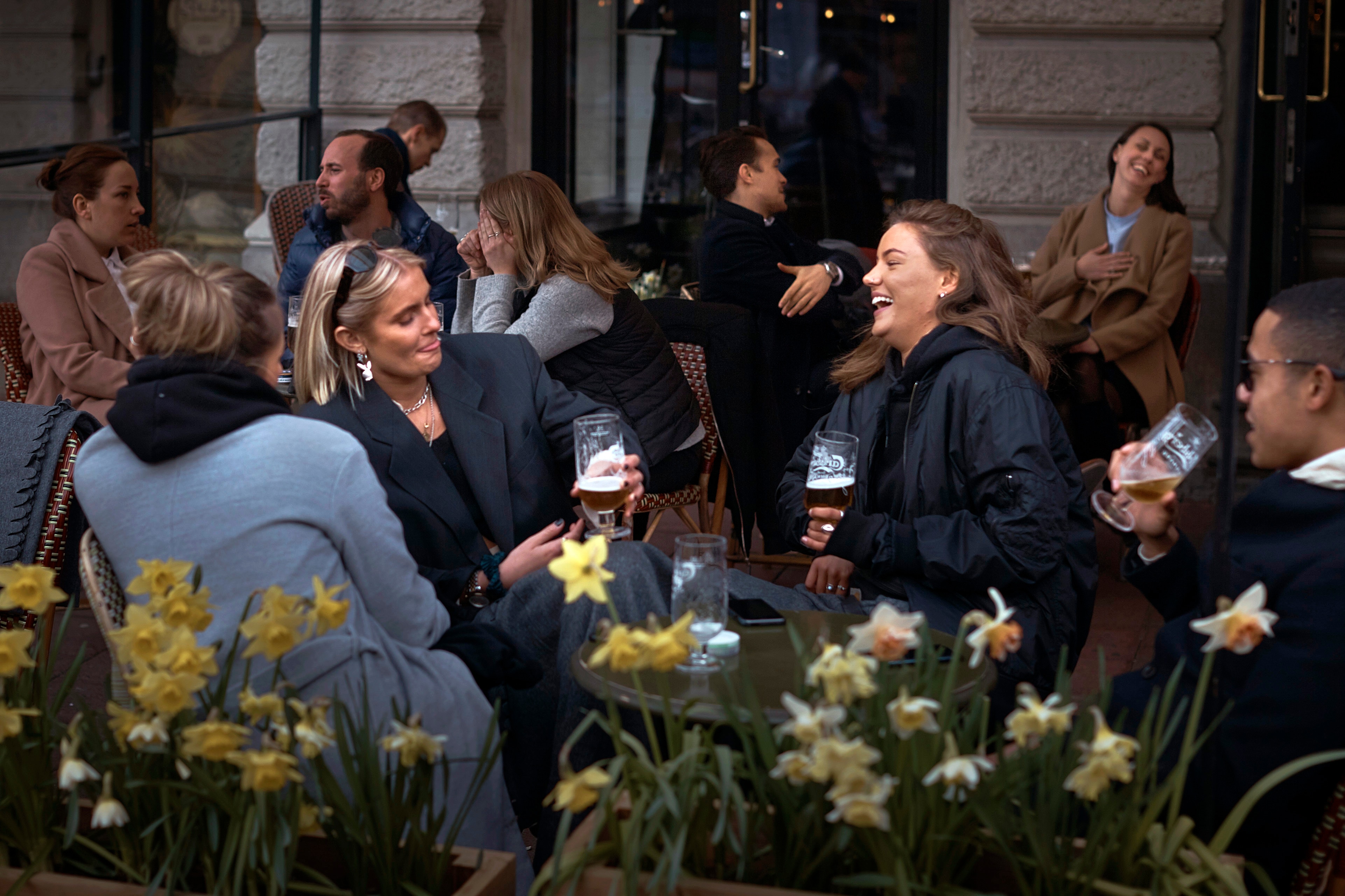 يتحدث الناس ويشربون خارج حانة في ستوكهولم بالسويد وسط جائحة فيروس كورونا.