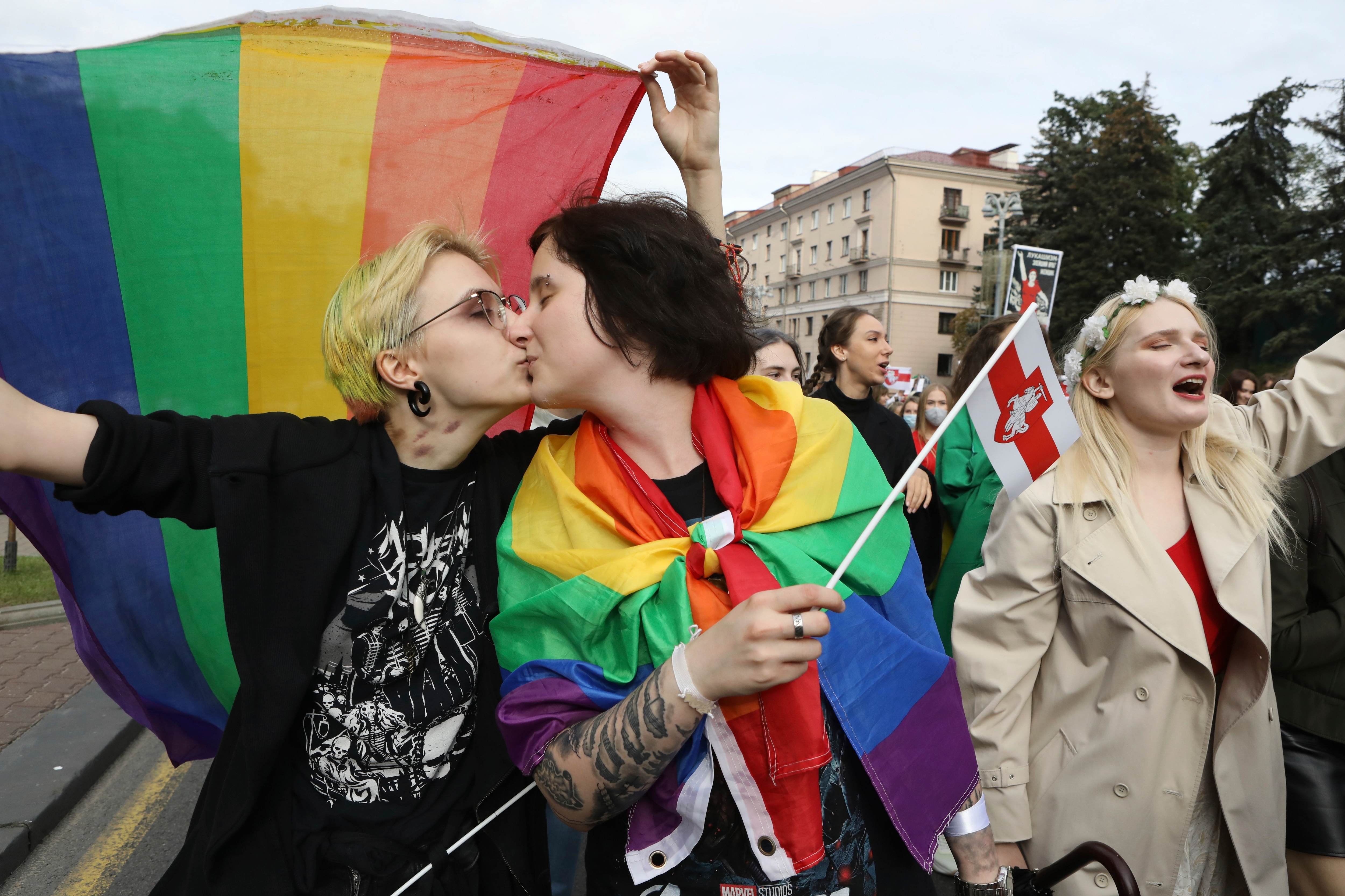 ناشطان من مجتمع الميم يتبادلان القبلات وهما يحملان أعلام قوس قزح خلال تجمع للمعارضة احتجاجًا على النتائج الرسمية للانتخابات الرئاسية في مينسك ، بيلاروسيا.