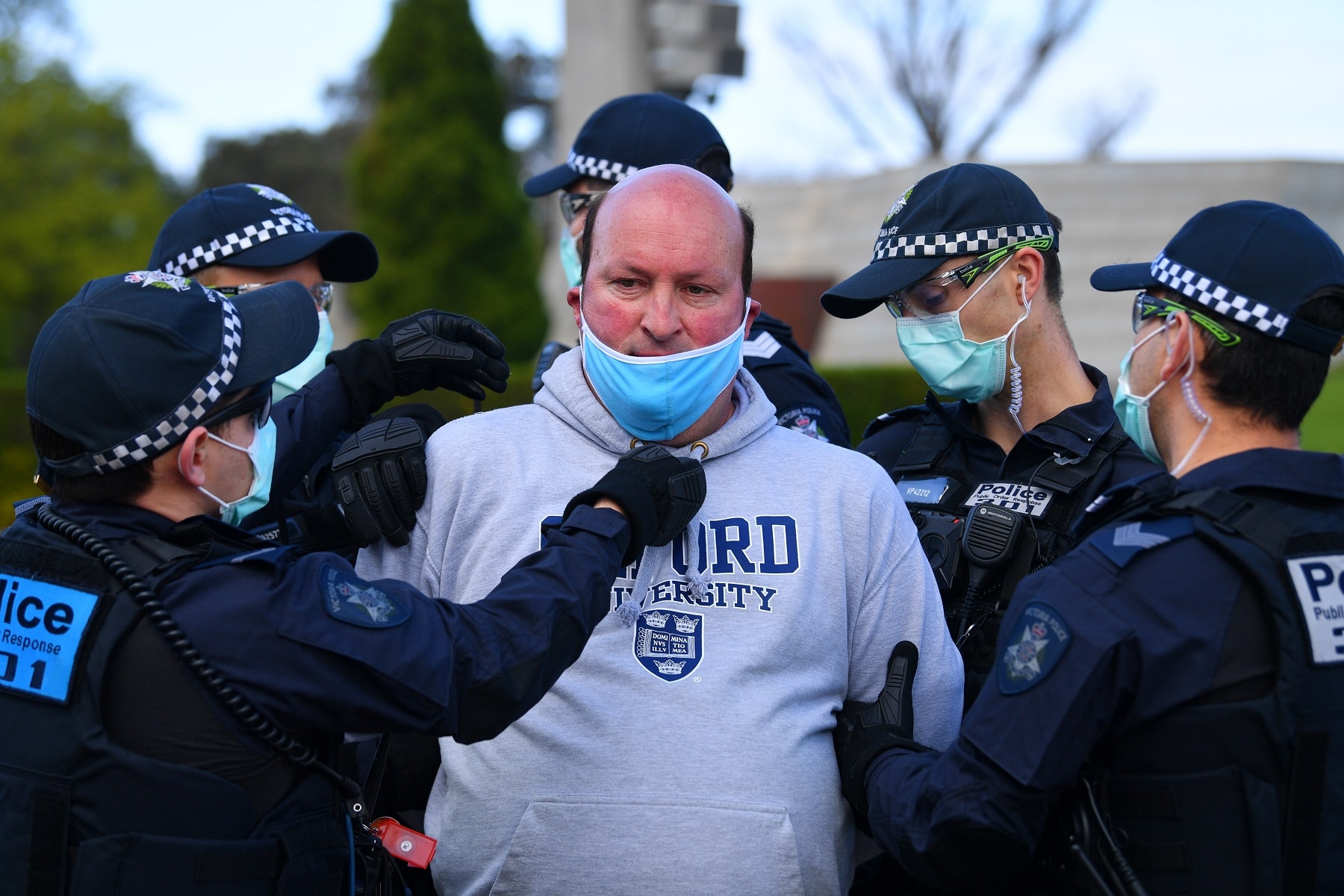شرطة فيكتوريا تعتقل متظاهرا وتضع قناع وجهه خارج ضريح الذكرى في ملبورن.