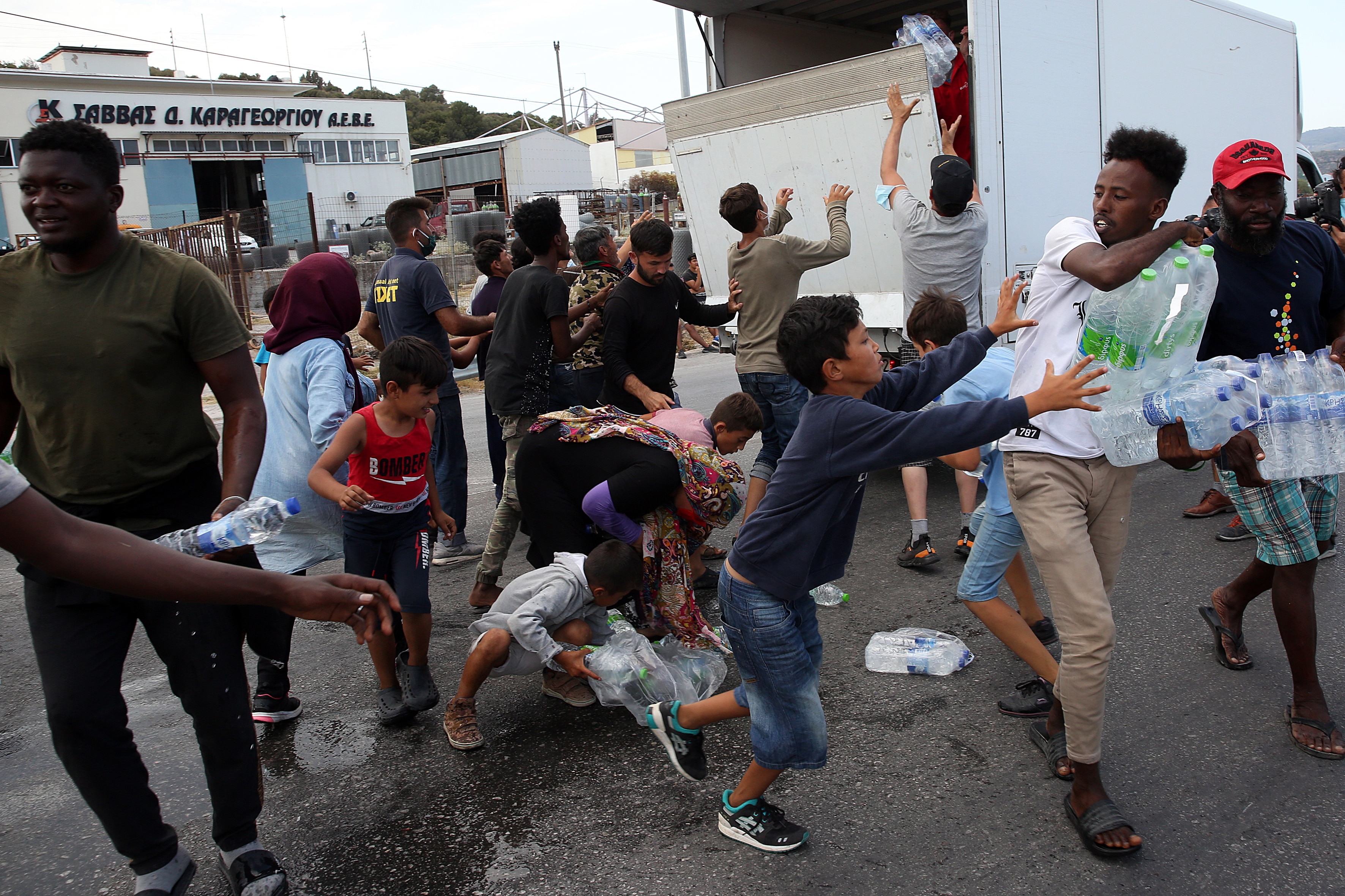 طالبو اللجوء يتشاجرون للحصول على بعض المياه بالقرب من المخيم الجديد في كارا تيبي في جزيرة ليسبوس ، اليونان ، في 12 سبتمبر.