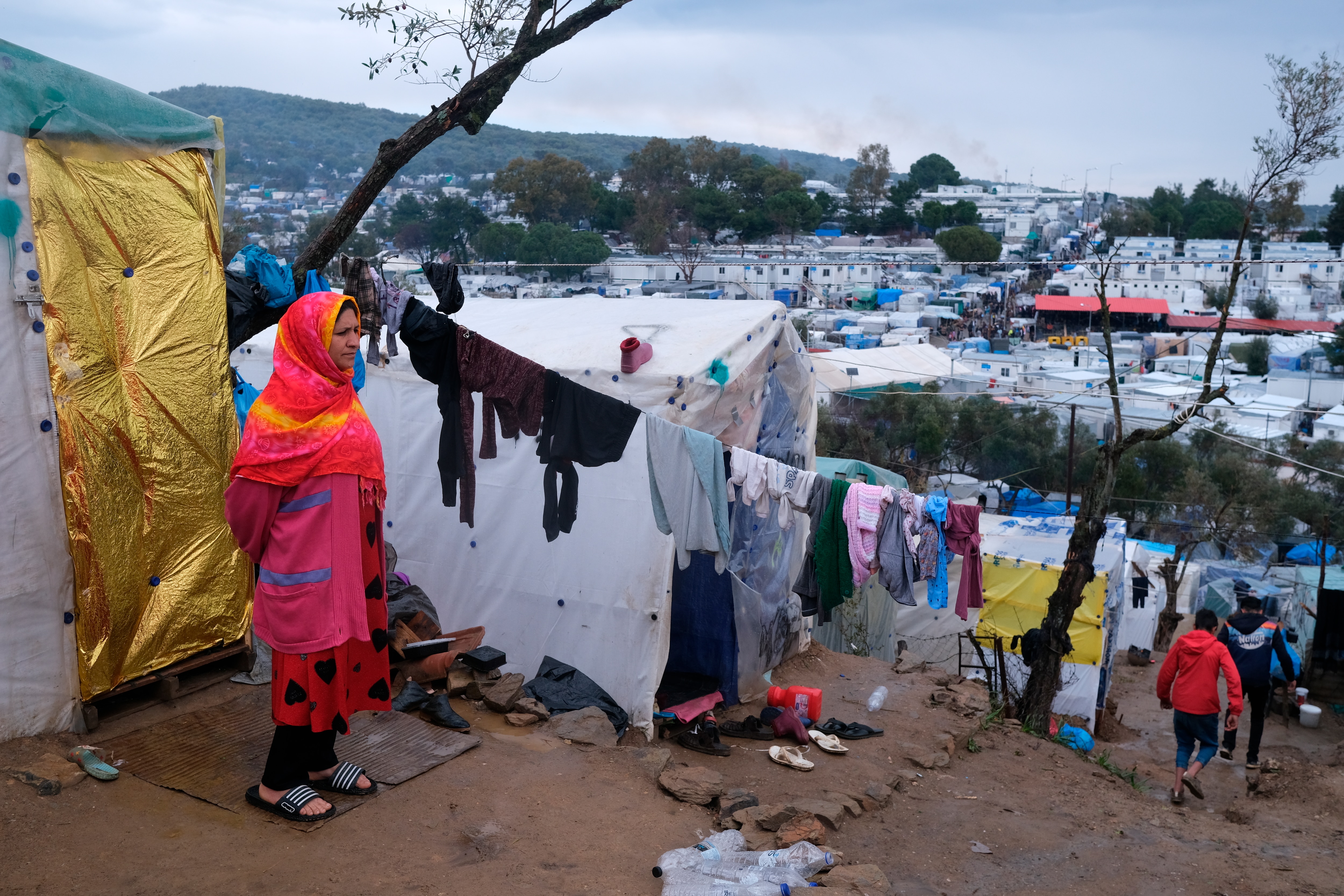 مهاجر يقف بجوار خيمته المؤقتة خارج محيط مخيم موريا المكتظ للاجئين في جزيرة ليسبوس شمال شرق بحر إيجة.