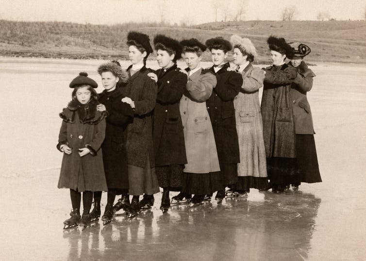 مجموعة من النساء الفيكتوريات تقف على بحيرة متجمدة.